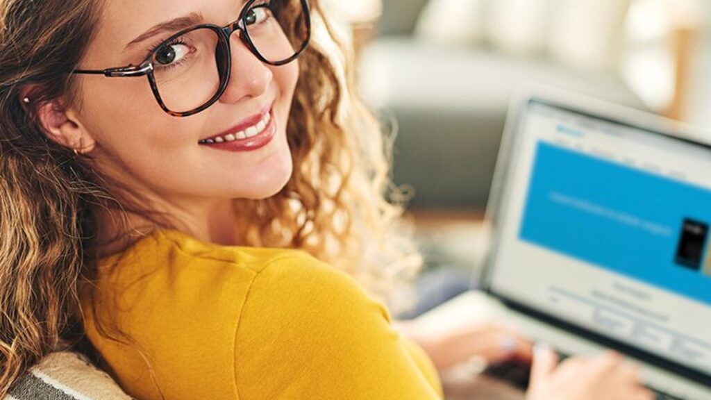 Woman smiling using laptop