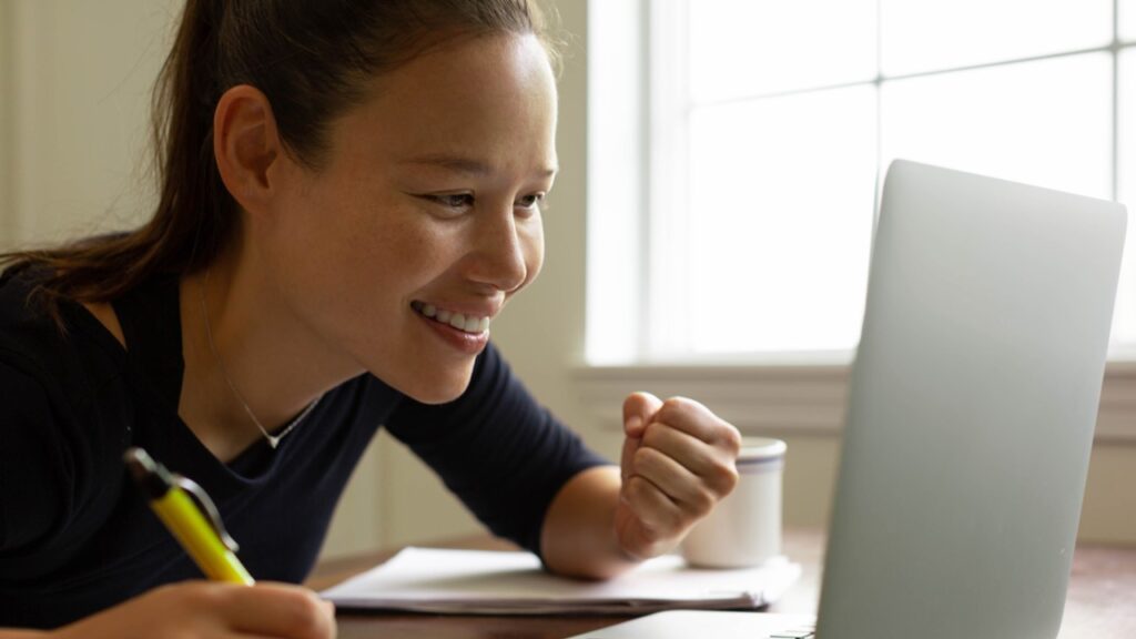 Cheering woman looking at screen