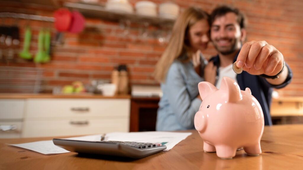 Couple putting coin in piggy bank