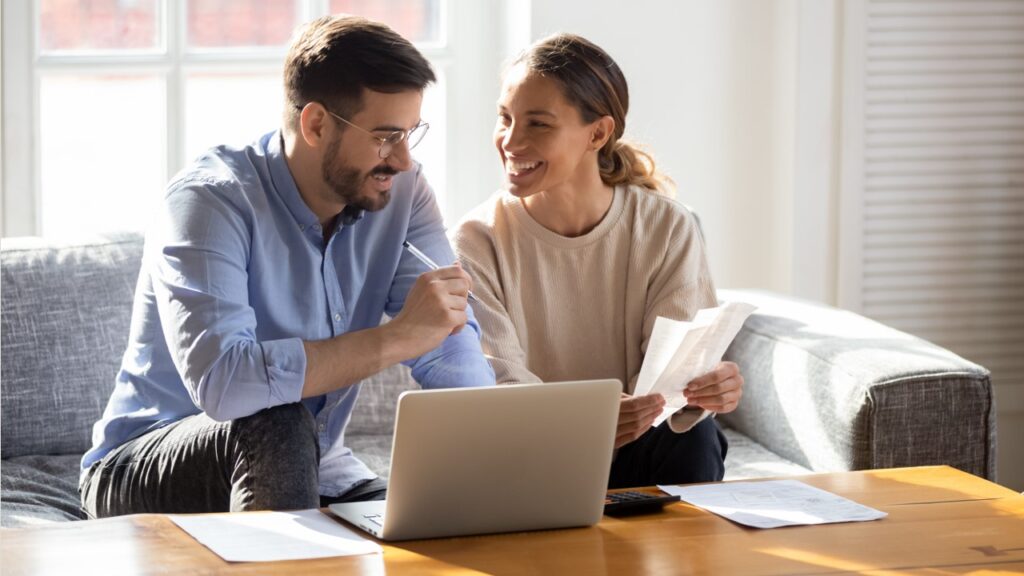 Couple dealing with finance paper in front of computer